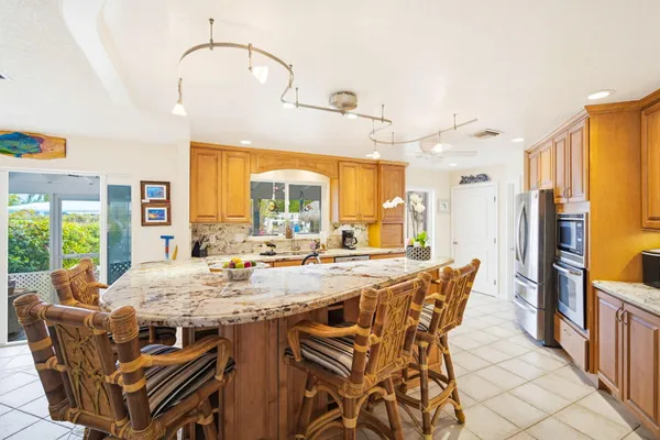 a view of a kitchen with furniture and stainless steel appliances