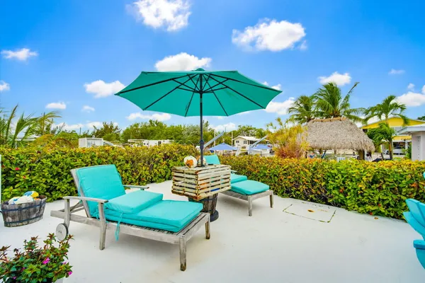 a view of a swimming pool with a patio and fire pit