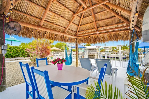 a view of a patio with a table and chairs under an umbrella