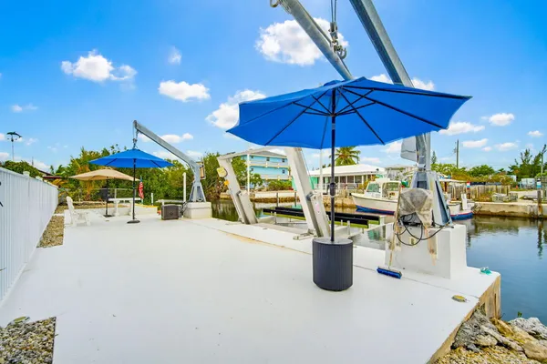 a view of lake with a table and chairs under an umbrella