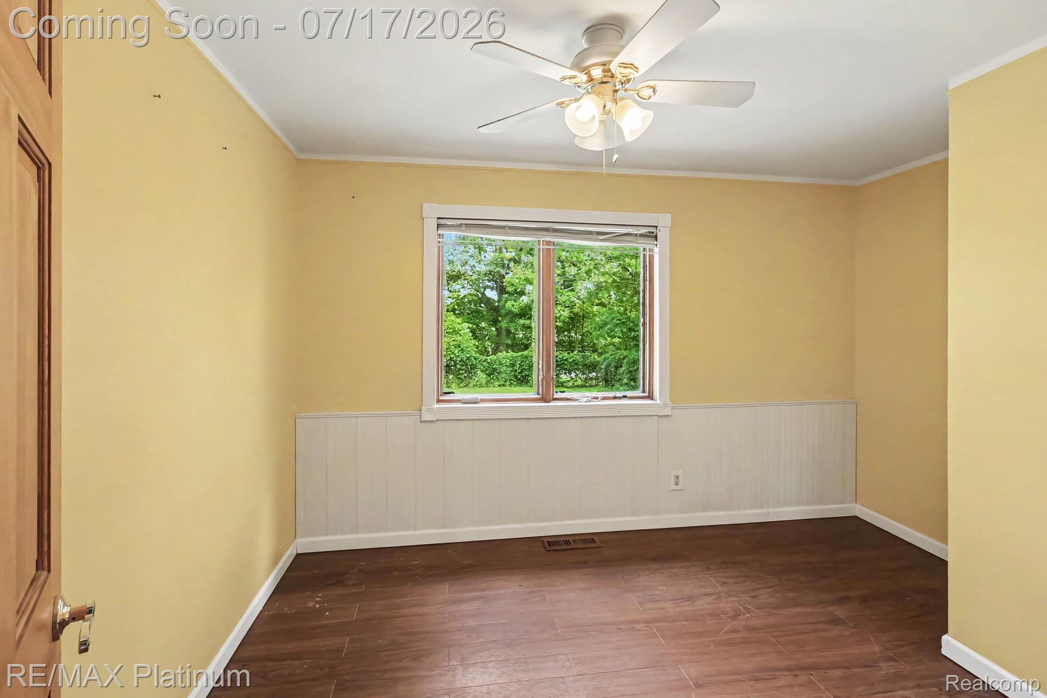 4205 Musson Road Howell, MI 48855 - Photo 14 of 23 Room featuring a window with natural light, wood-finish flooring, white wainscoting, and a ceiling fan with integrated lighting