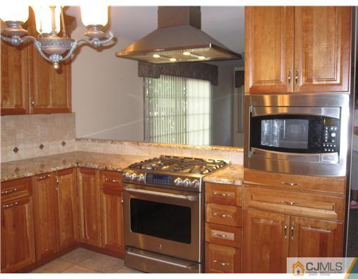 18 Timber Road Edison, NJ 08820 - Photo 2 of 13 a kitchen with stainless steel appliances granite countertop a stove and a microwave