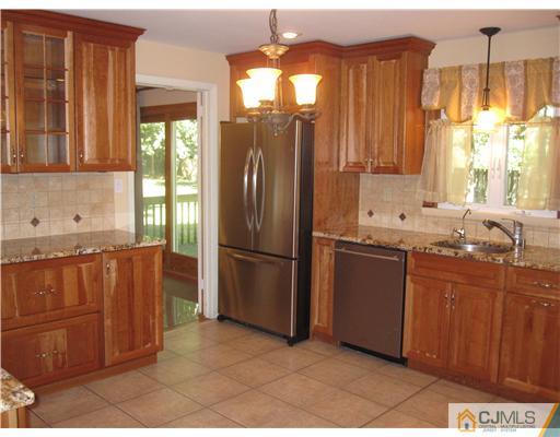 18 Timber Road Edison, NJ 08820 - Photo 3 of 13 a kitchen with stainless steel appliances granite countertop a refrigerator a sink dishwasher and wooden cabinets