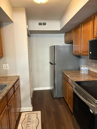 a kitchen with stainless steel appliances granite countertop a refrigerator a sink and a stove