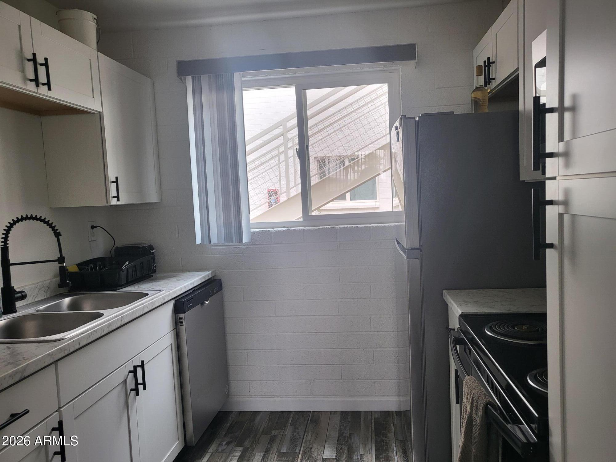 815 North Hayden Road, Unit B109 Scottsdale, AZ 85257 - Photo 4 of 25 a kitchen with a sink stove and refrigerator