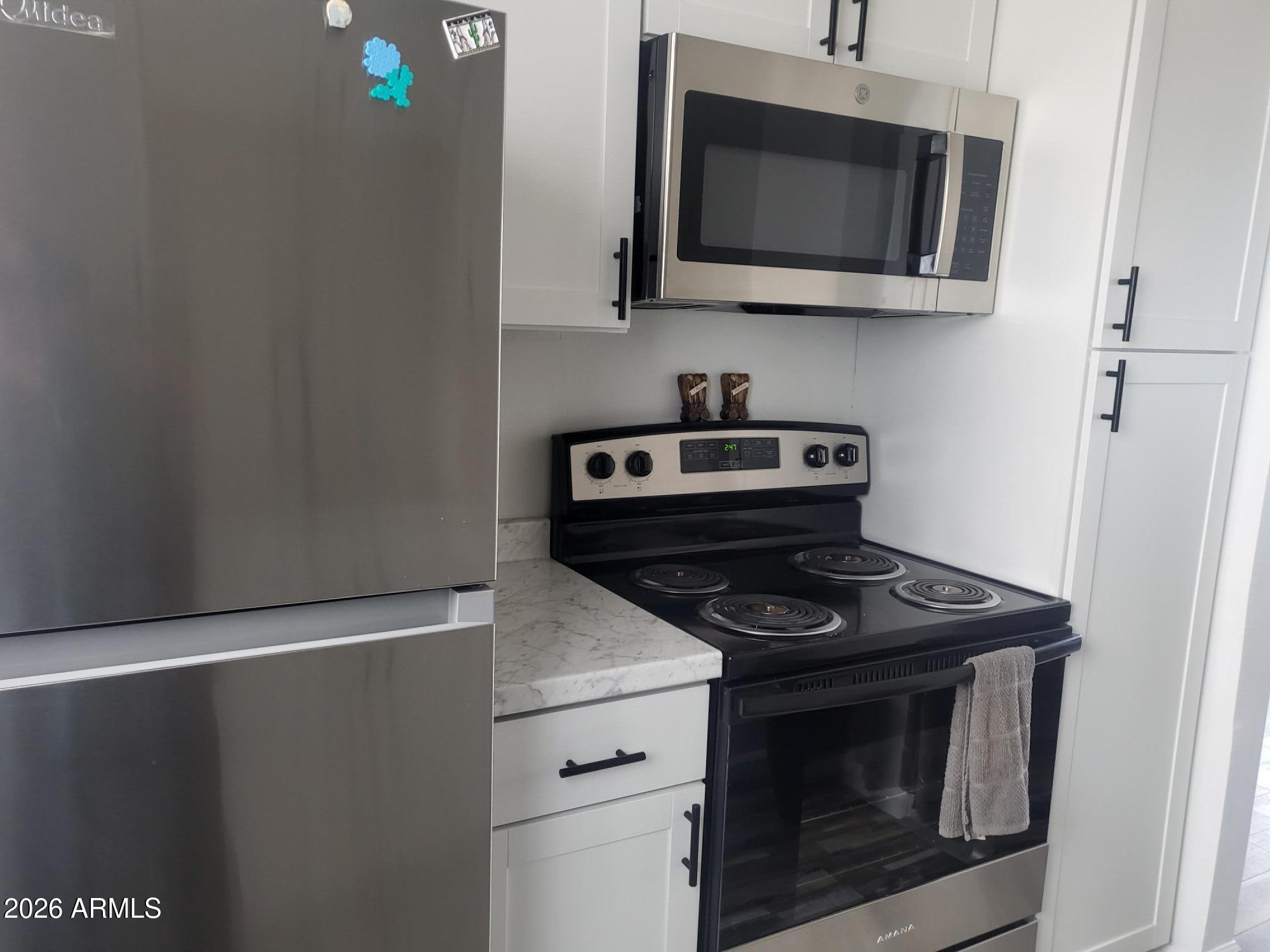 815 North Hayden Road, Unit B109 Scottsdale, AZ 85257 - Photo 6 of 25 a kitchen with microwave and stove