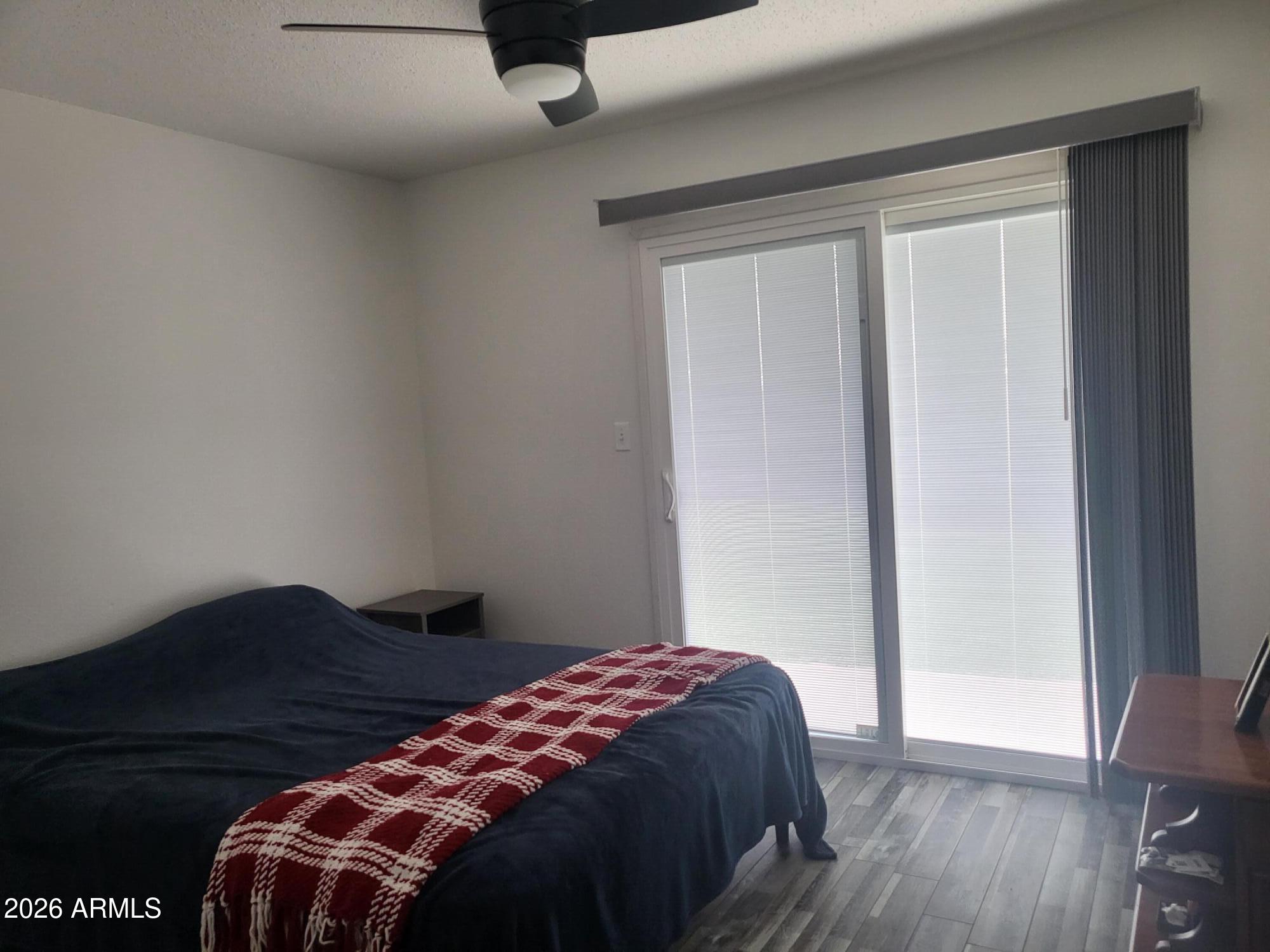 815 North Hayden Road, Unit B109 Scottsdale, AZ 85257 - Photo 9 of 25 a bedroom with a bed and wooden floor