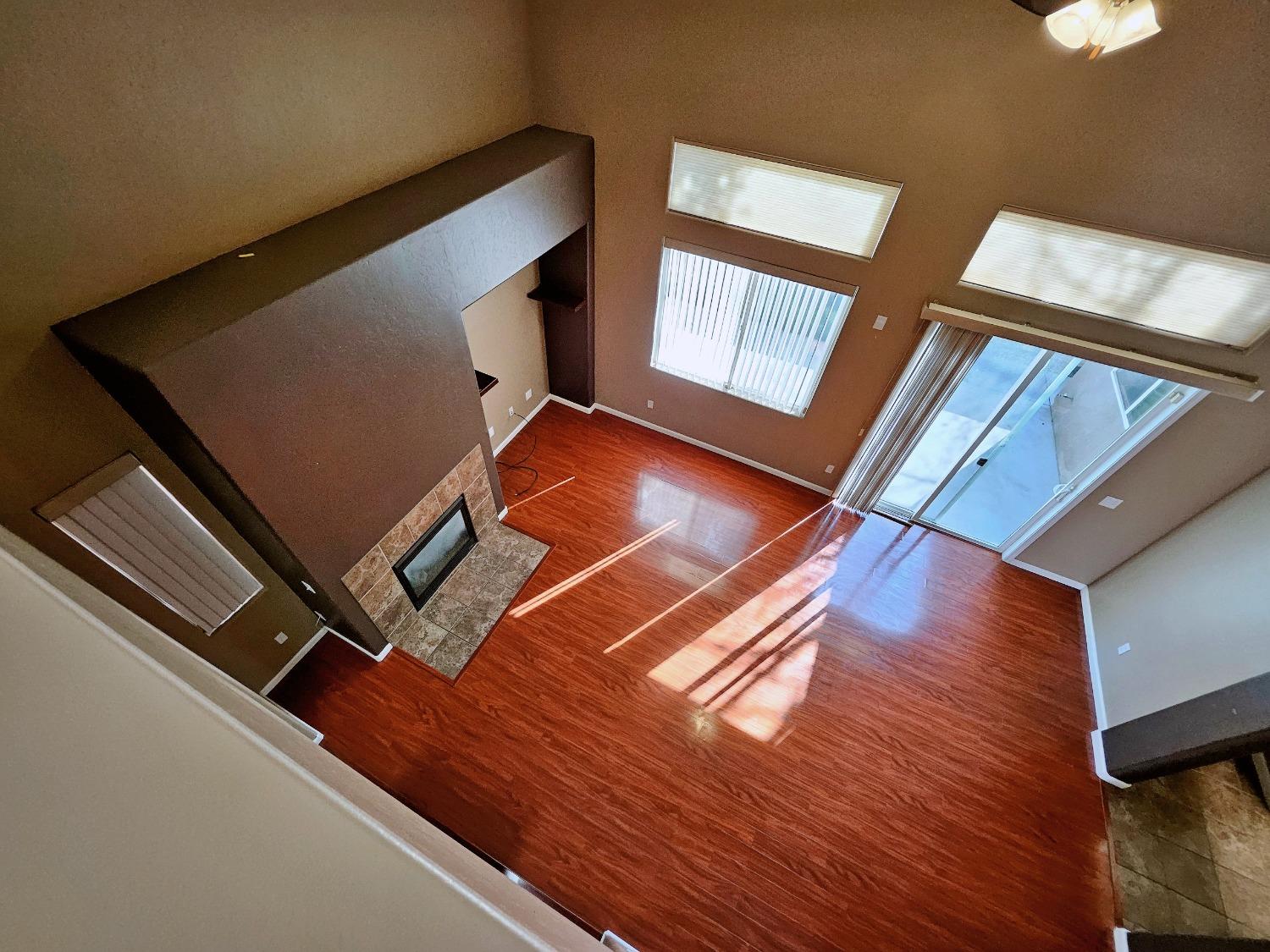 828 Tureaud Lane Clovis, CA 93619 - Photo 13 of 24 a view of an empty room with wooden floor and windows