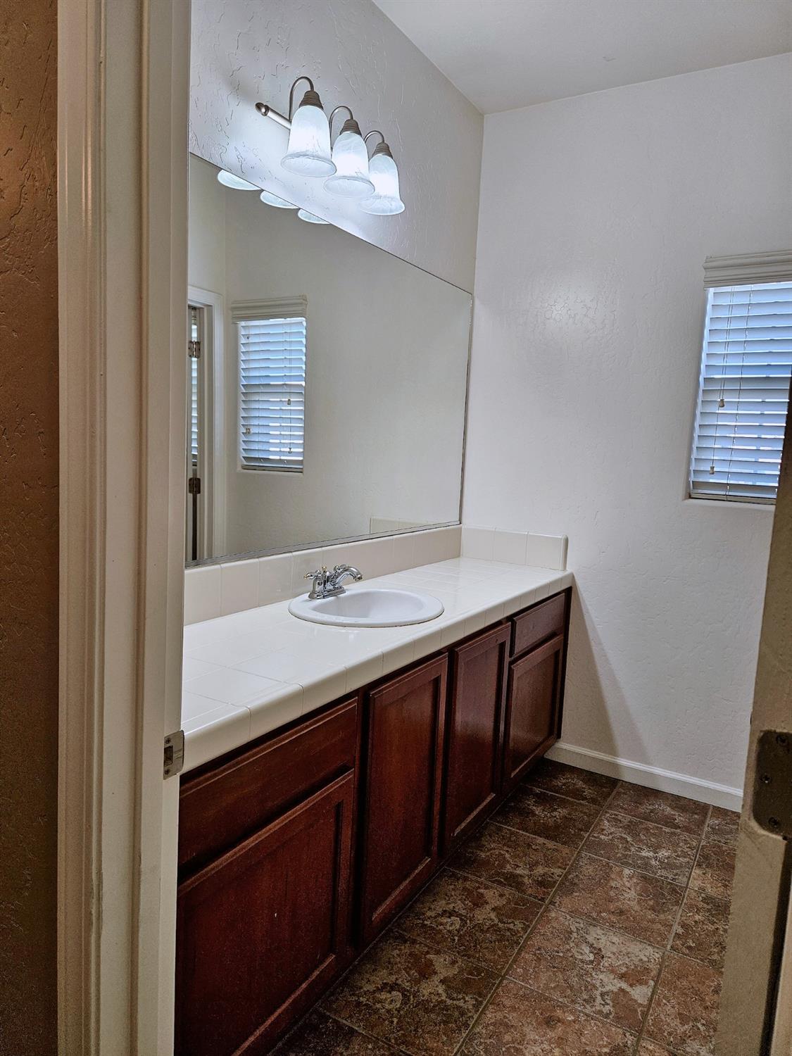 828 Tureaud Lane Clovis, CA 93619 - Photo 20 of 24 a bathroom with a sink and a mirror
