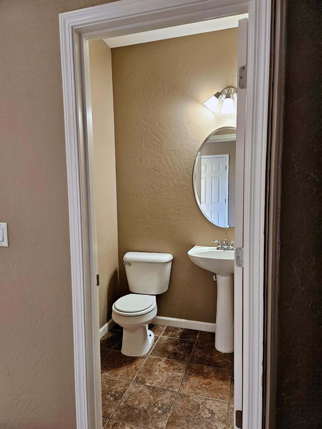 828 Tureaud Lane Clovis, CA 93619 - Photo 5 of 24 a bathroom with a toilet a sink and mirror