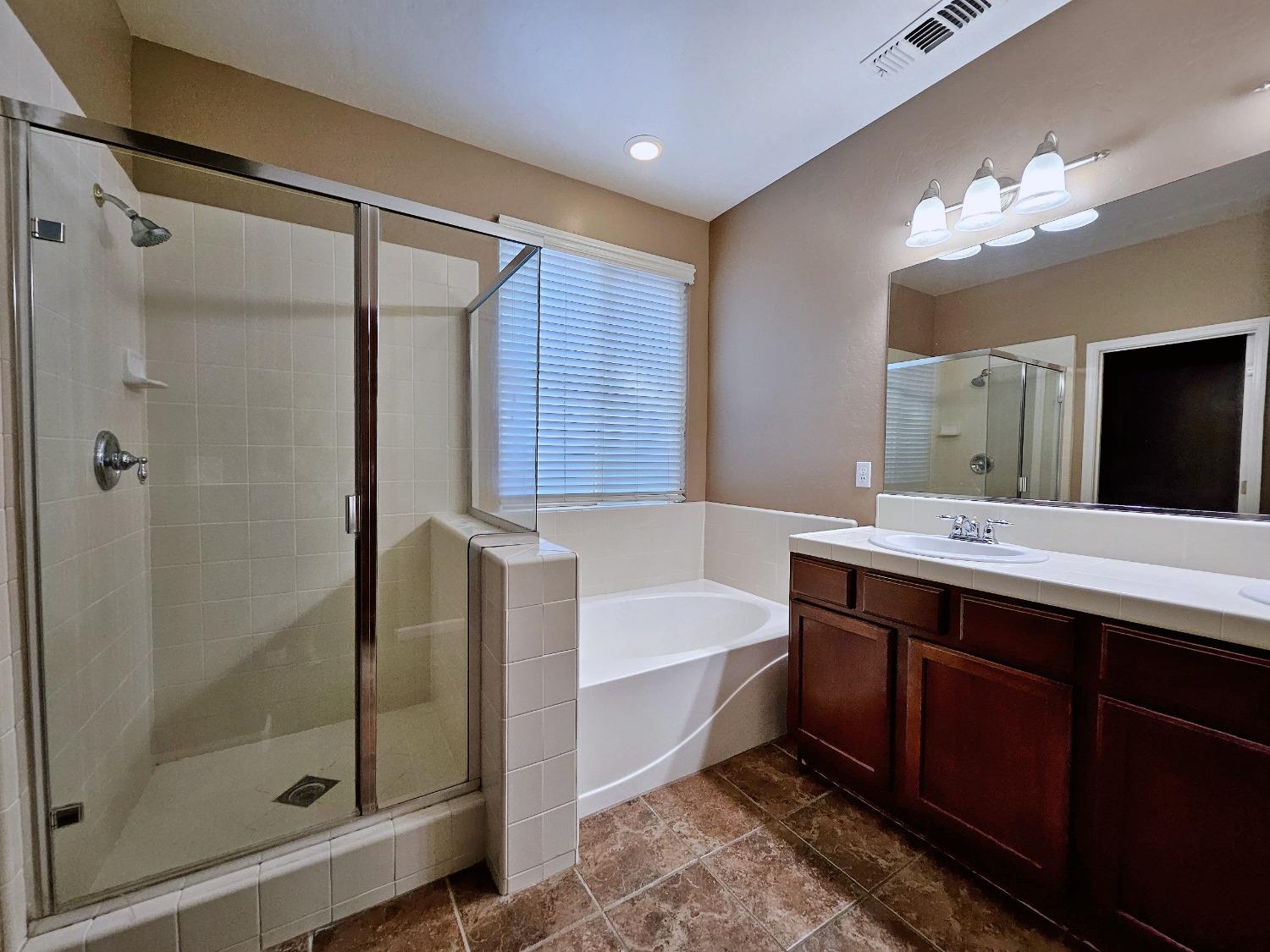 828 Tureaud Lane Clovis, CA 93619 - Photo 8 of 24 a bathroom with a double vanity sink mirror and shower