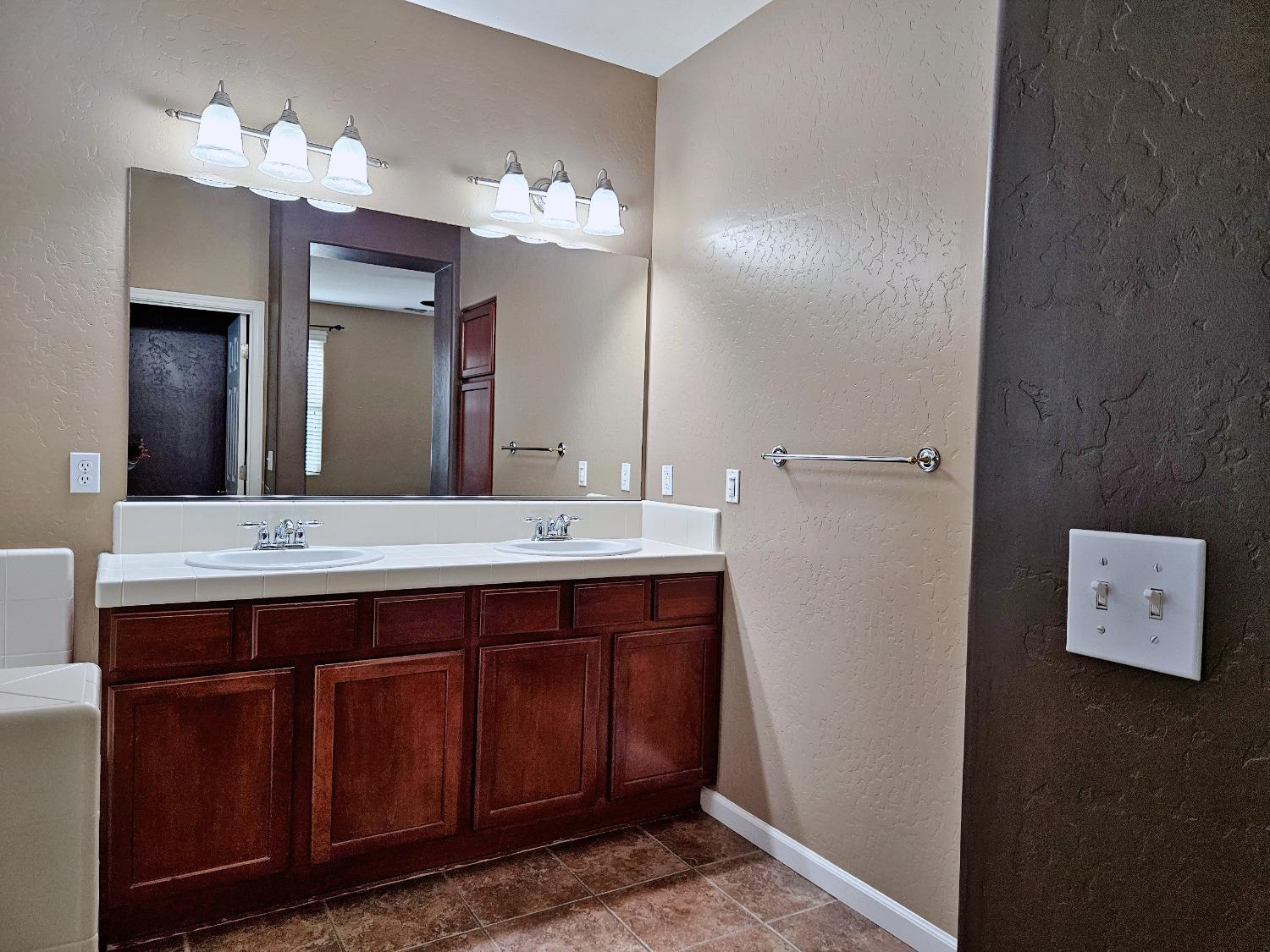 828 Tureaud Lane Clovis, CA 93619 - Photo 9 of 24 a bathroom with a double vanity sink and a mirror