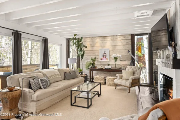 a living room with furniture fireplace and a large window