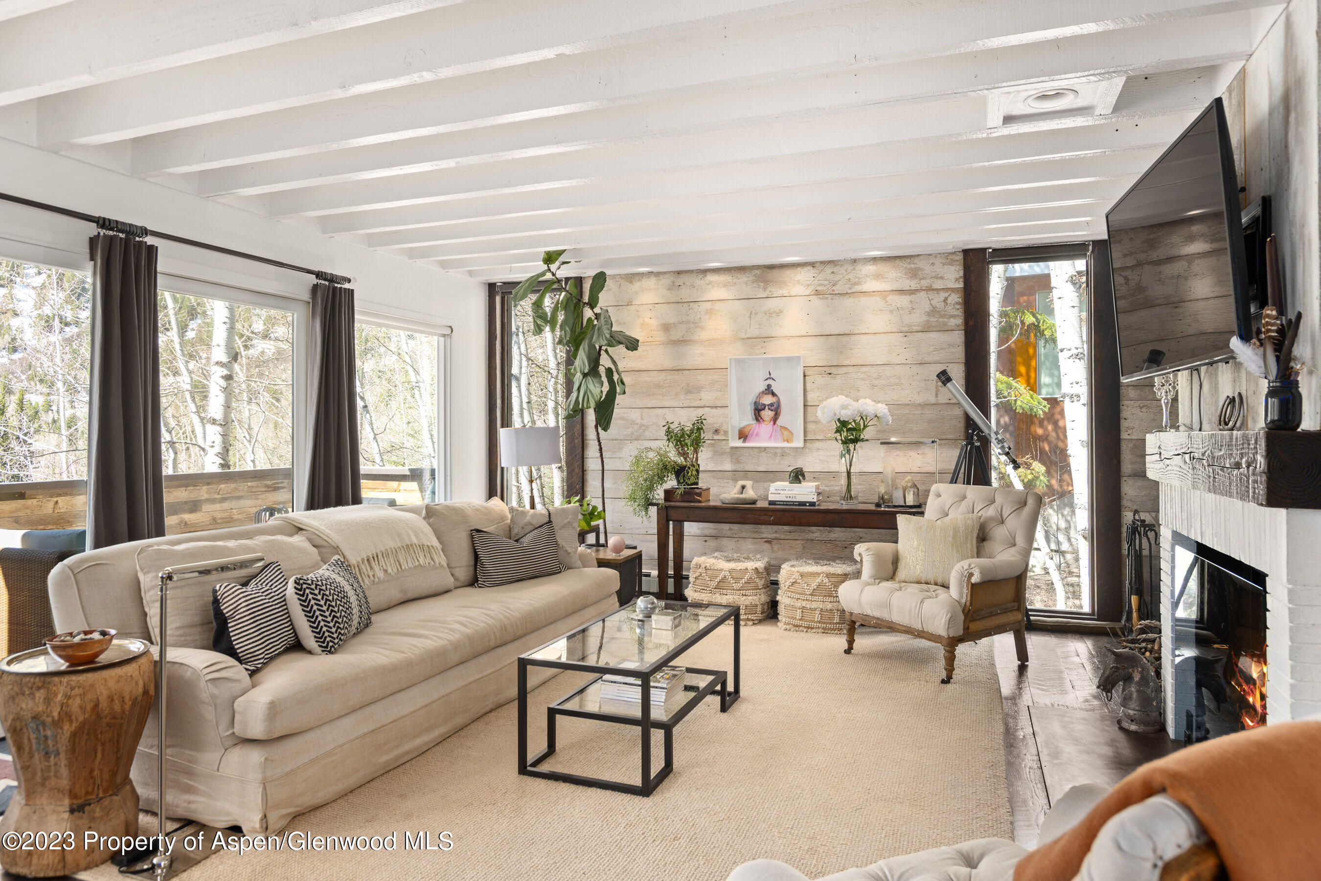 a living room with furniture fireplace and a large window