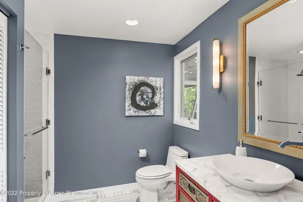 a bathroom with a granite countertop sink a toilet and a mirror