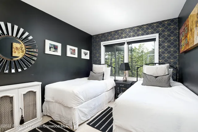 a bedroom with two beds and a large window