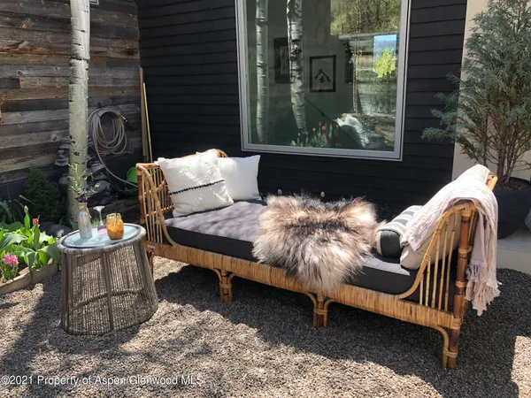 a view of backyard with outdoor seating and plants