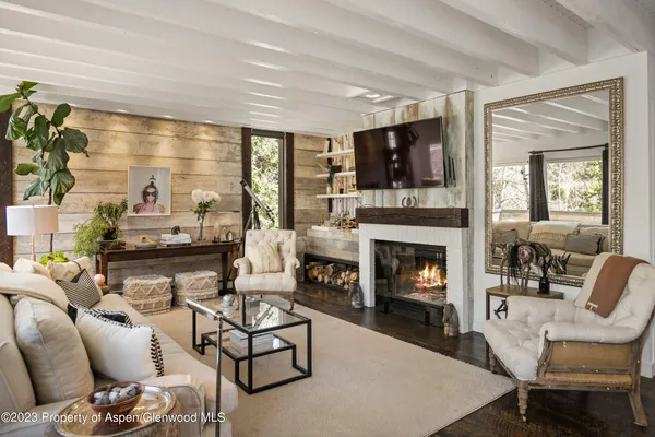 a living room with furniture a flat screen tv and a fireplace