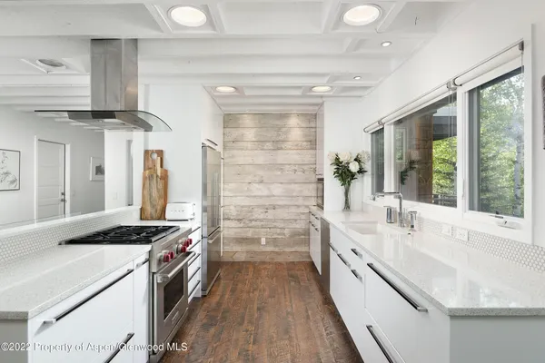 a kitchen with granite countertop a sink stove and cabinets