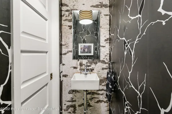 a bathroom with a sink and mirror with bathtub
