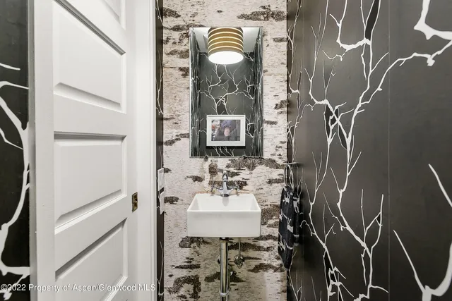 a bathroom with a sink and mirror with bathtub
