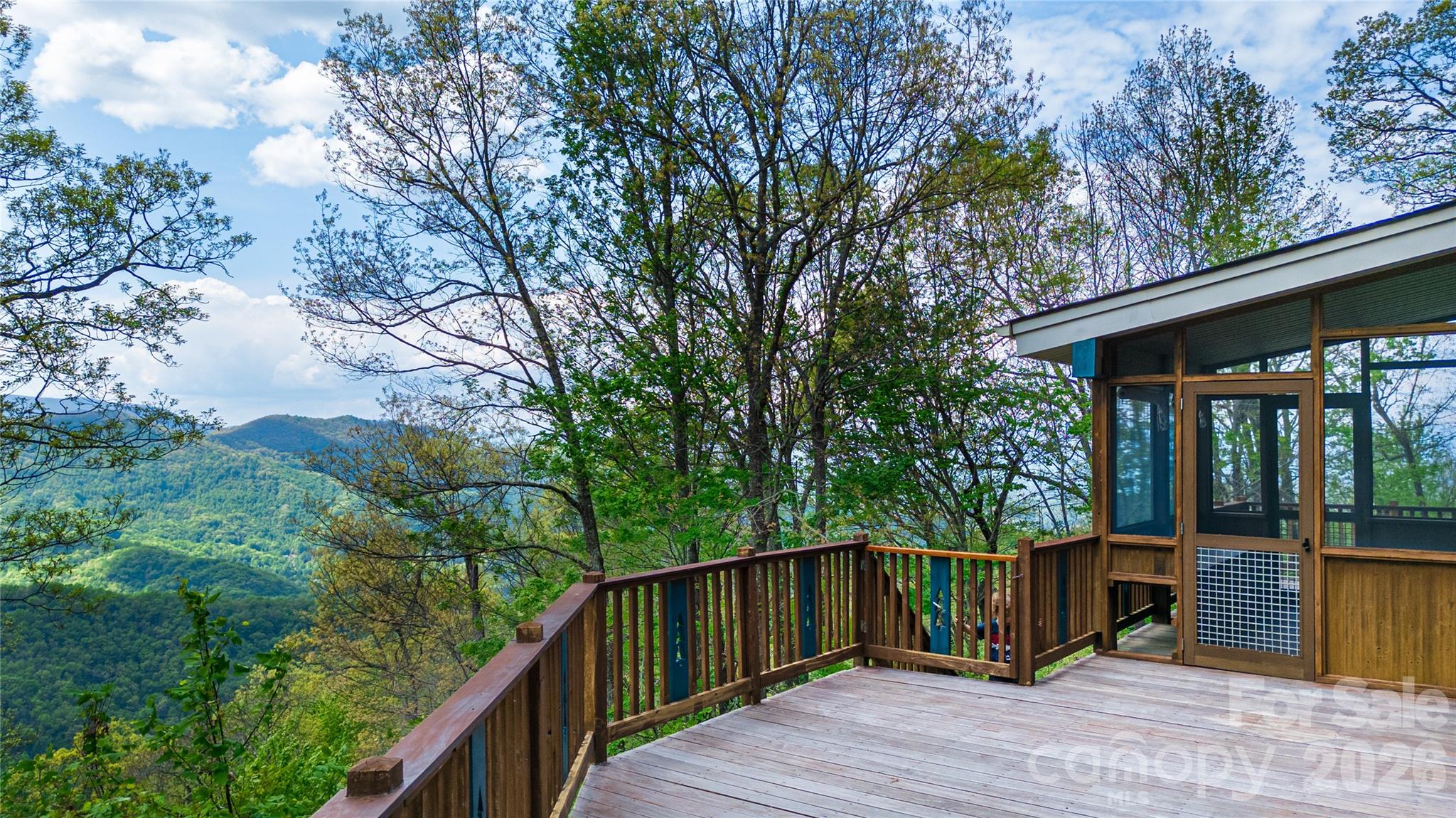 1602 Forest Run Road Whittier, NC 28789 - Photo 12 of 42 a balcony with wooden floor and fence next to a yard