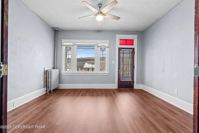 wooden floor in an empty room with a window