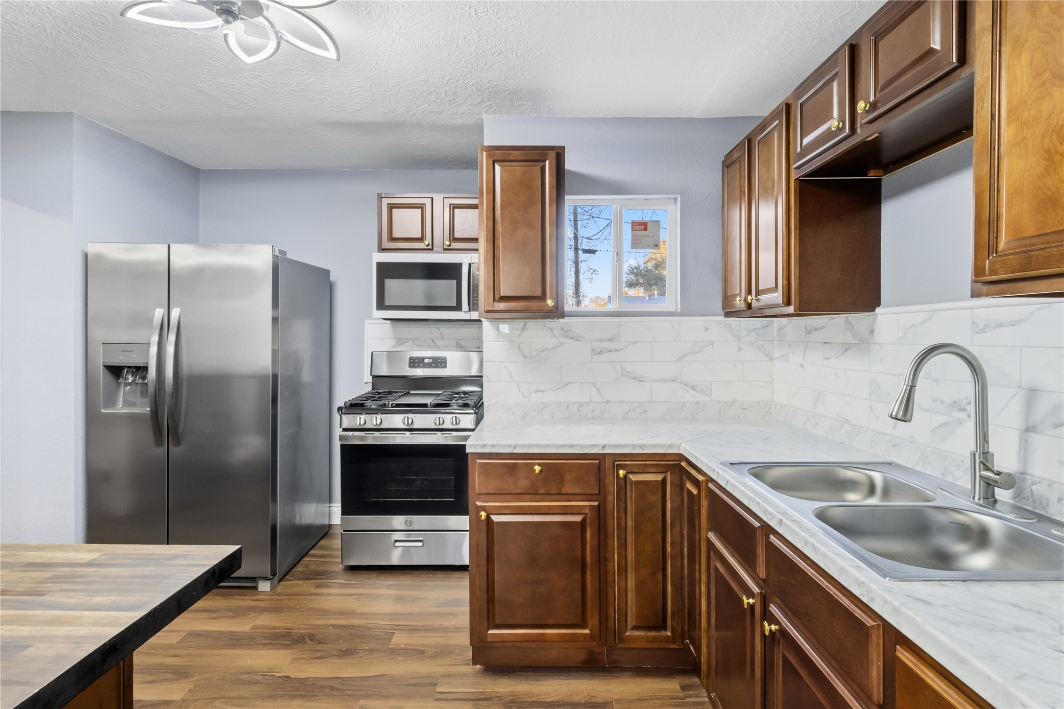 901 South 7th Street Baytown, TX 77520 - Photo 14 of 36 a kitchen with stainless steel appliances granite countertop a sink stove and refrigerator