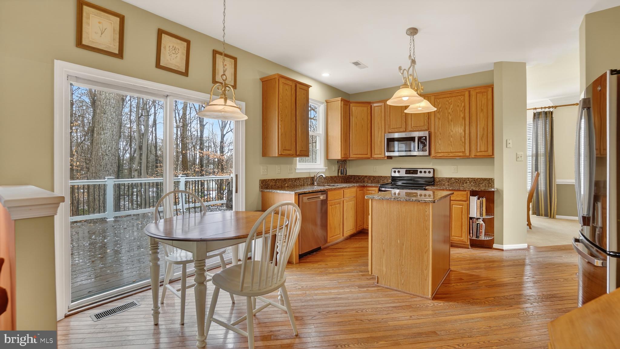2806 Erna Court Crofton, MD 21054 - Photo 17 of 60 a kitchen with stainless steel appliances granite countertop a stove top oven a sink a dining table and chairs with wooden floor