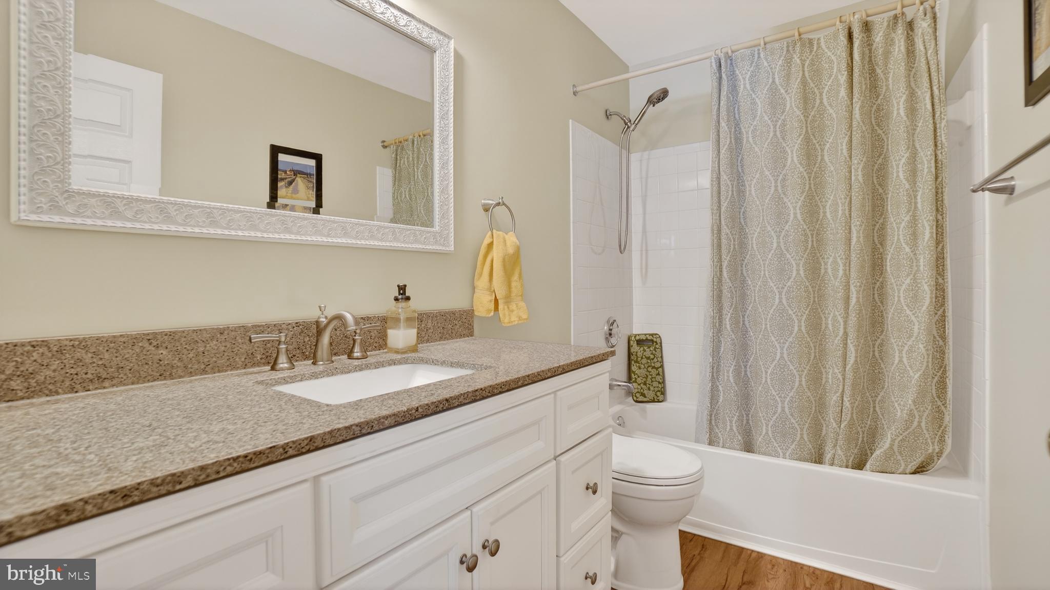 2806 Erna Court Crofton, MD 21054 - Photo 40 of 60 a bathroom with a granite countertop sink a toilet and a mirror
