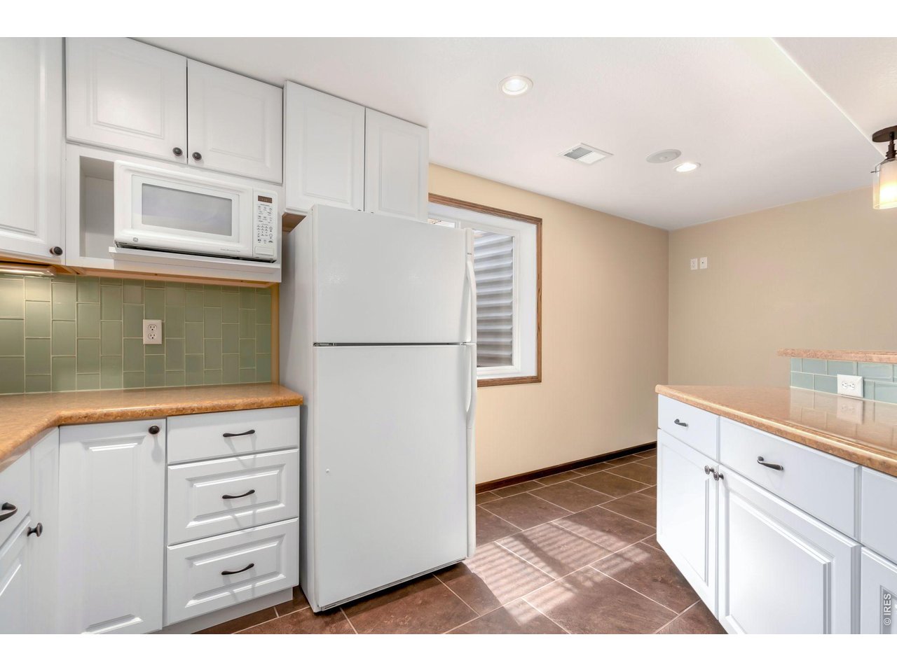 3779 Mount Meeker Street Wellington, CO 80549 - Photo 21 of 30 a kitchen with white cabinets and white appliances