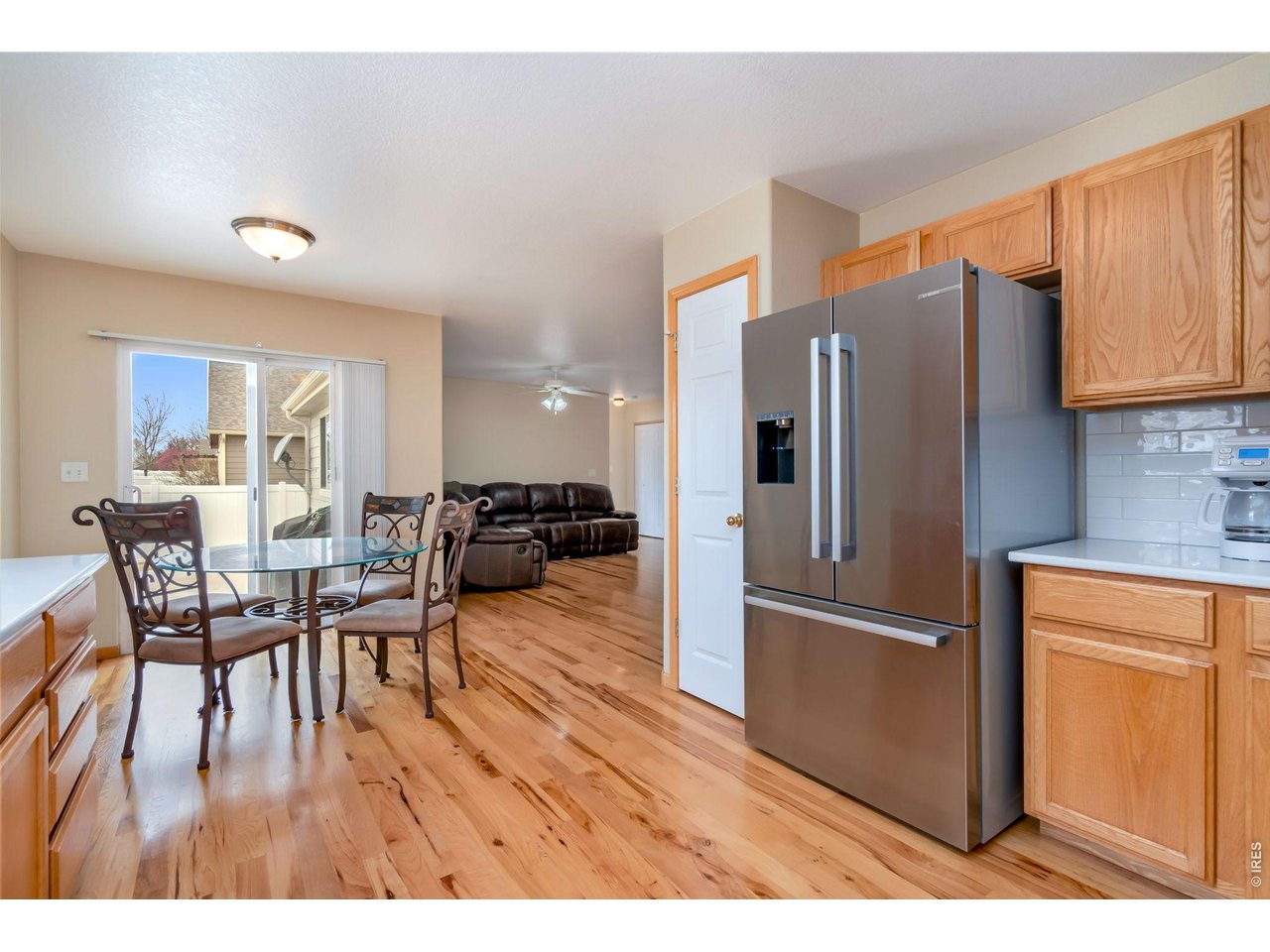 3779 Mount Meeker Street Wellington, CO 80549 - Photo 6 of 30 a kitchen with stainless steel appliances granite countertop a refrigerator and a dining table