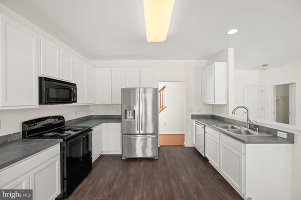 a kitchen with stainless steel appliances granite countertop a stove a sink and a refrigerator