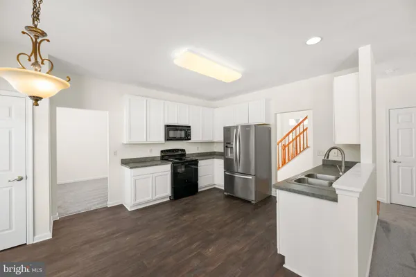 a kitchen with stainless steel appliances granite countertop a refrigerator stove and sink