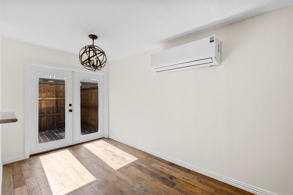 4039 Cole Avenue, Unit 105 Dallas, TX 75204 - Photo 11 of 39 Unfurnished dining area with baseboards, wood finished floors, french doors, a chandelier, and a wall mounted AC