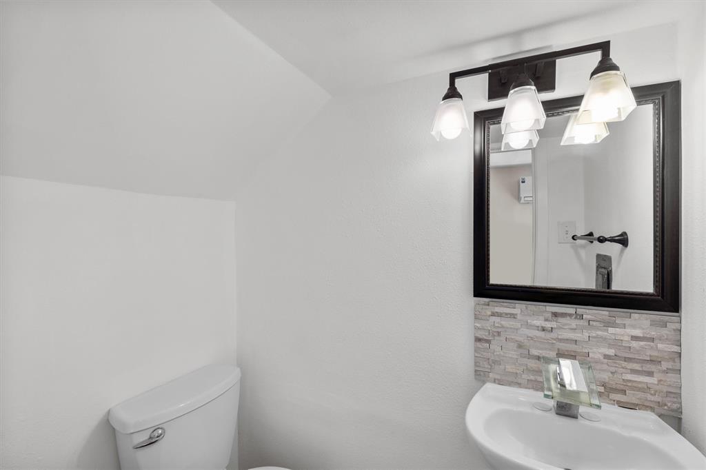 4039 Cole Avenue, Unit 105 Dallas, TX 75204 - Photo 16 of 39 Bathroom featuring lofted ceiling, a sink, and toilet