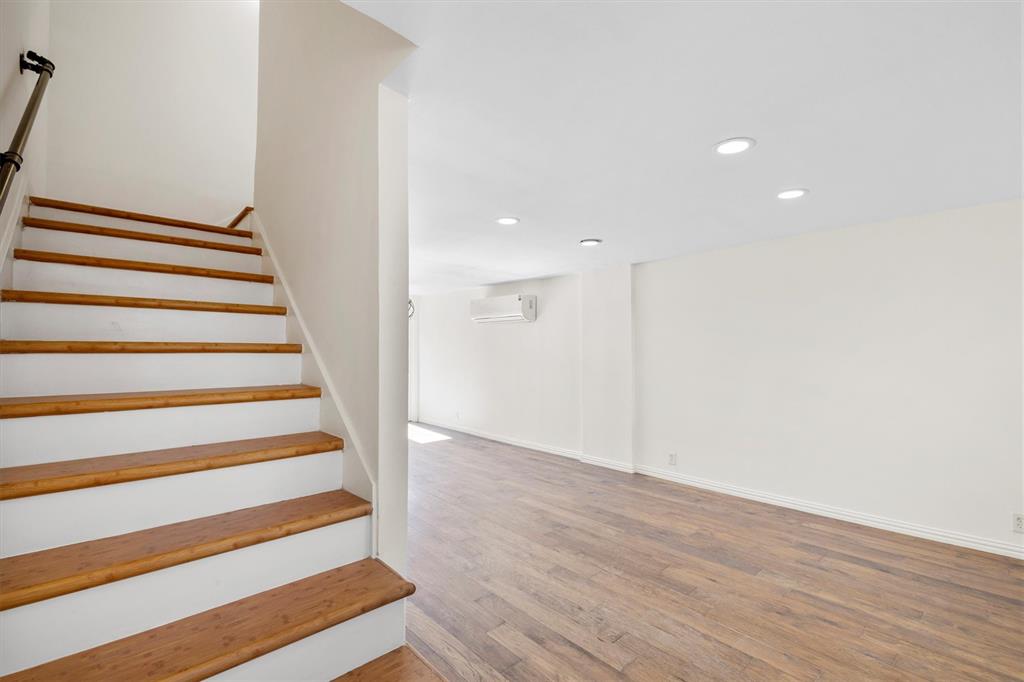 4039 Cole Avenue, Unit 105 Dallas, TX 75204 - Photo 17 of 39 Stairs with recessed lighting, baseboards, wood finished floors, and a wall mounted air conditioner