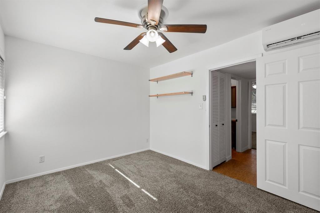 4039 Cole Avenue, Unit 105 Dallas, TX 75204 - Photo 21 of 39 Carpeted bedroom with a wall mounted AC, a ceiling fan, and baseboards