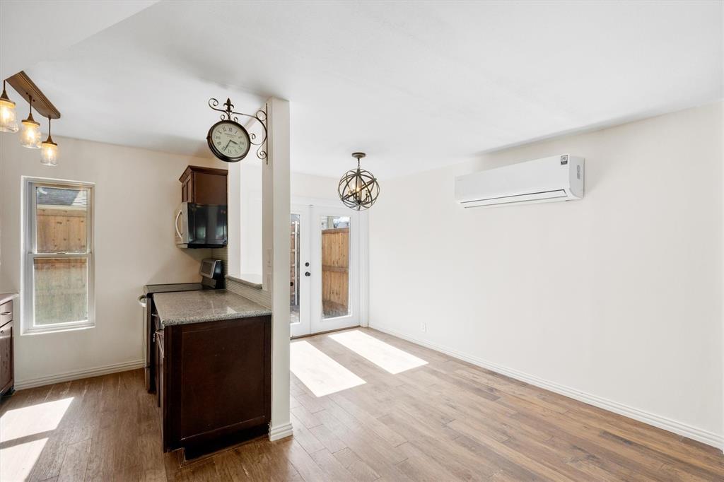 4039 Cole Avenue, Unit 105 Dallas, TX 75204 - Photo 10 of 39 Kitchen with appliances with stainless steel finishes, an AC wall unit, a healthy amount of sunlight, and wood finished floors