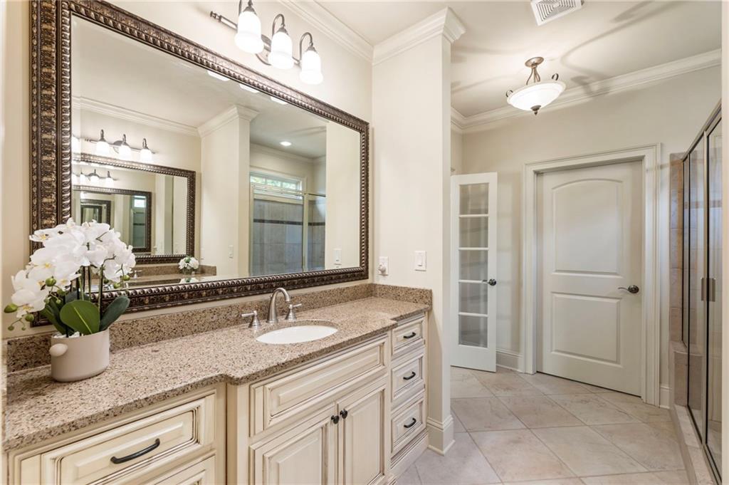 2472 Ballantrae Circle Cumming, GA 30041 - Photo 18 of 41 a bathroom with a granite countertop sink a large mirror and a shower