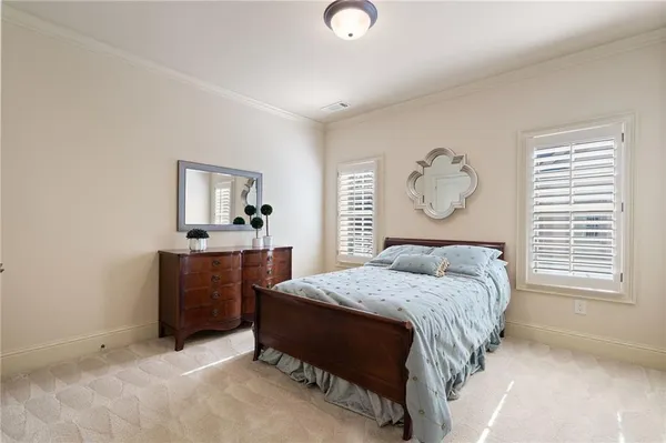 a bedroom with a bed a mirror on dresser and a window