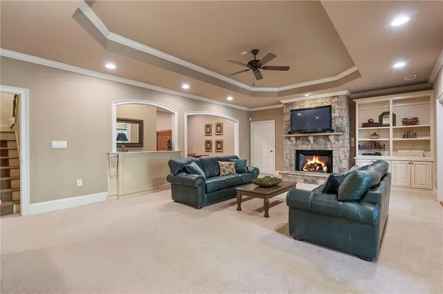 a living room with furniture a fireplace and a ceiling fan