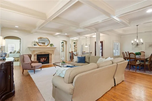 a living room with furniture a fireplace and a chandelier