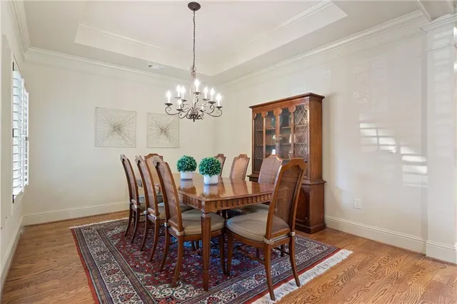 a view of a dining room with furniture a chandelier and wooden floor