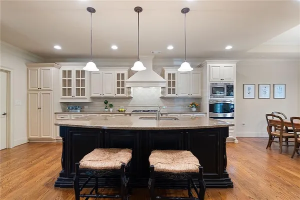 a kitchen with kitchen island a dining table and chairs