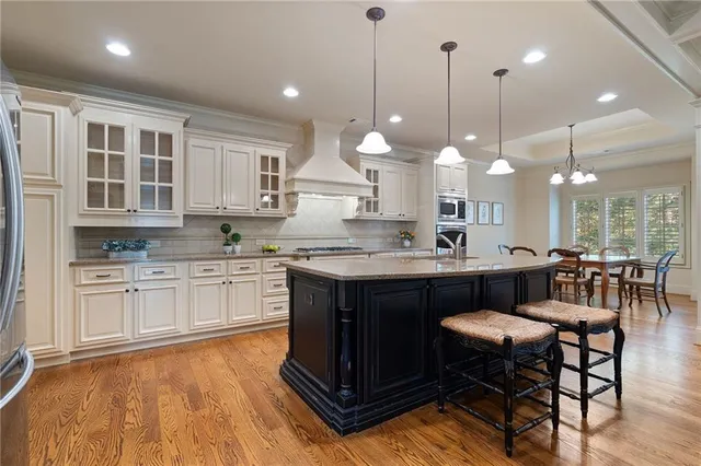 a kitchen with kitchen island granite countertop a sink cabinets and wooden floor