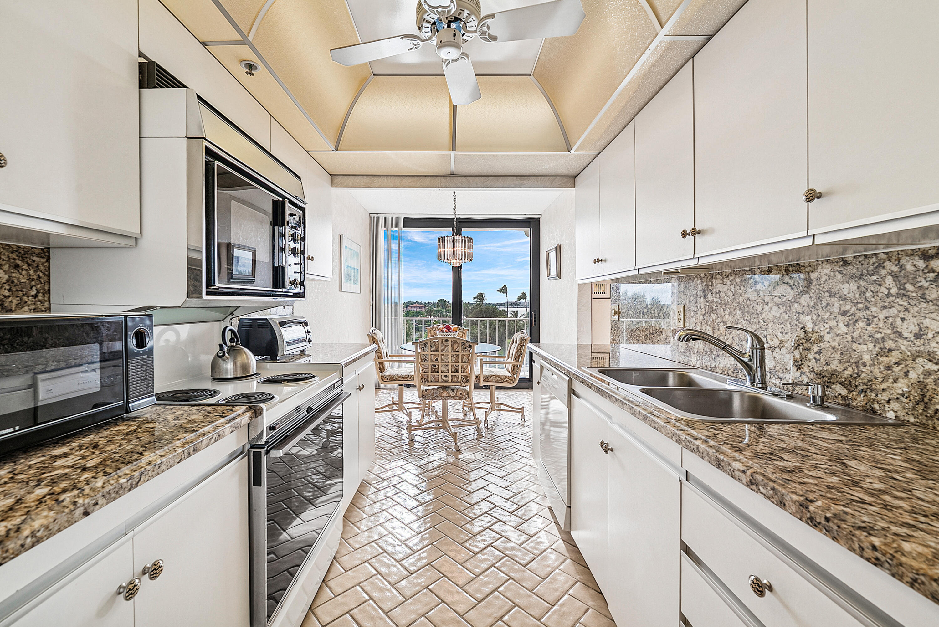 3400 South Ocean Boulevard, Unit 3HI Palm Beach, FL 33480 - Photo 11 of 50 a kitchen with granite countertop a sink a counter top space appliances and cabinets