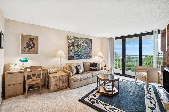 a living room with furniture flat screen tv and a floor to ceiling window