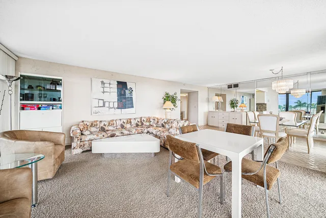 a dining room with furniture a chandelier and wooden floor