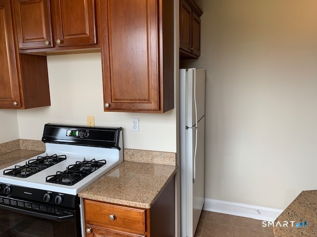 50 Glenbrook Road, Unit 5G Stamford, CT 06902 - Photo 22 of 40 a kitchen with granite countertop a stove and a refrigerator